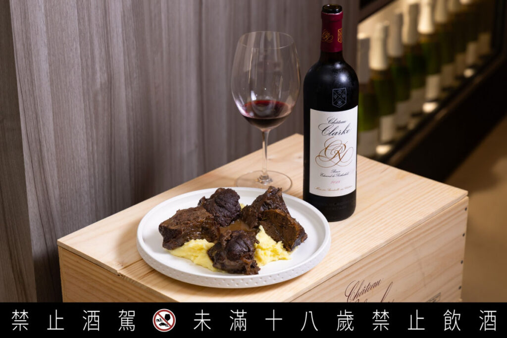 高訂小酒館為核心的橙花商店,提供AA 級品飲體驗。搶先體驗 2026 薄酒萊新酒的風味預測或是酒神慶典的百款世界級名莊佳釀,滿足葡萄酒愛好者對高品質微醺生活的渴望。圖為Clarke 2018 Rouge搭配經典勃艮第燉牛頰